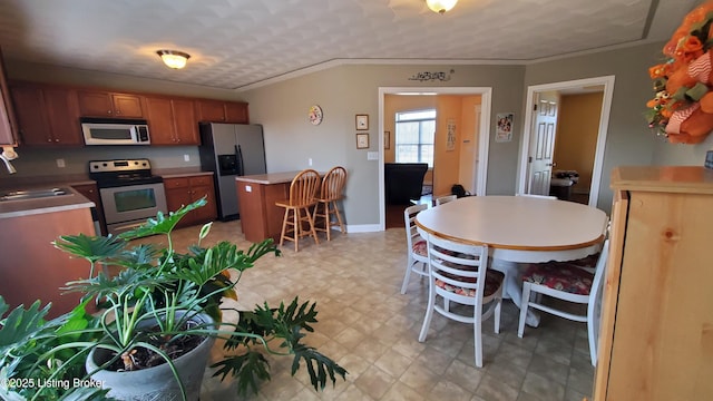 dining area with crown molding and sink