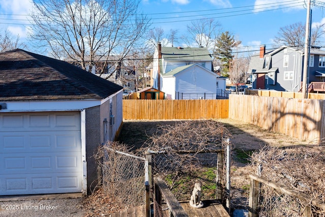 view of yard with a garage and an outbuilding