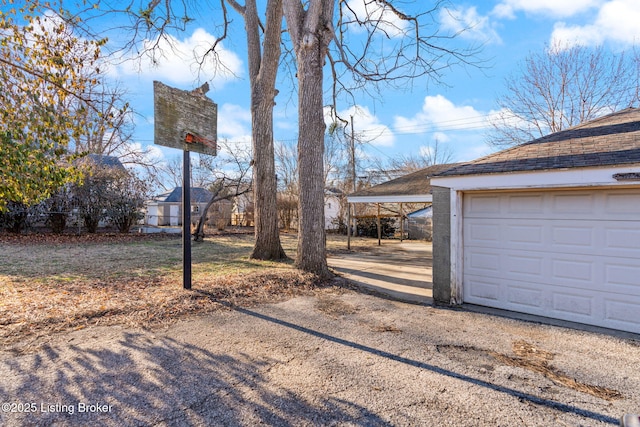 view of yard featuring a carport, a garage, and an outdoor structure