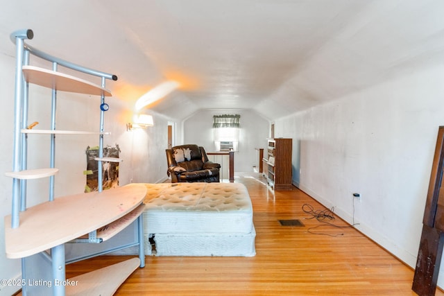 sitting room with wood-type flooring and vaulted ceiling