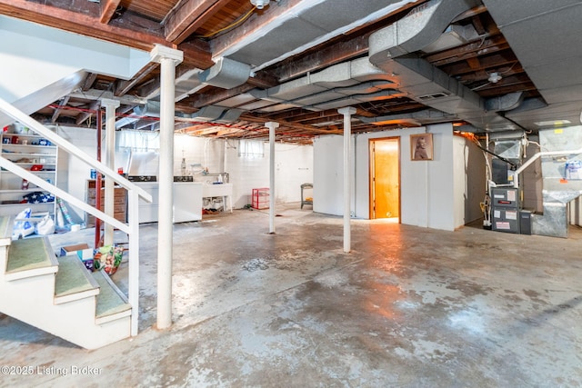 basement featuring heating unit, sink, and washer and dryer