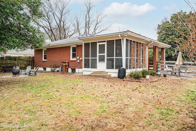 back of property featuring a patio, a sunroom, and an outdoor fire pit