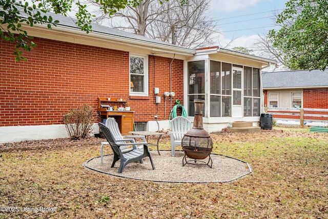 rear view of house with a fire pit and a sunroom