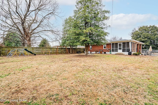 view of yard with a playground and a sunroom