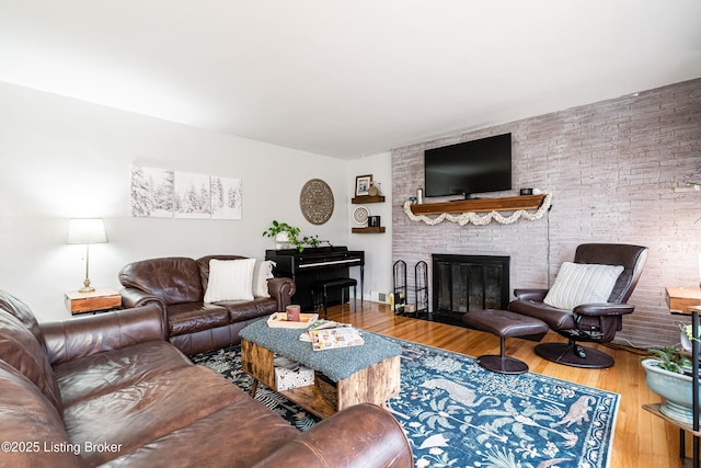 living room featuring a brick fireplace and hardwood / wood-style floors