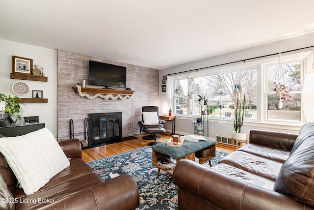 living room with a brick fireplace and hardwood / wood-style floors