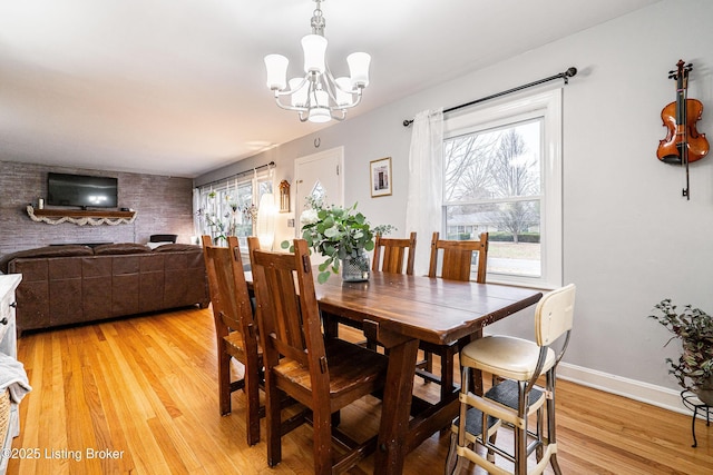 dining area with an inviting chandelier, plenty of natural light, and light hardwood / wood-style flooring