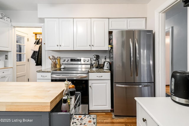 kitchen featuring appliances with stainless steel finishes, light wood-type flooring, and white cabinets