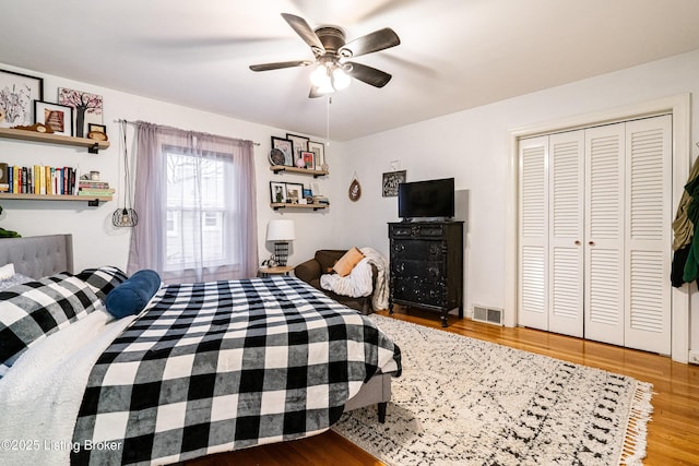 bedroom with hardwood / wood-style flooring, a closet, and ceiling fan