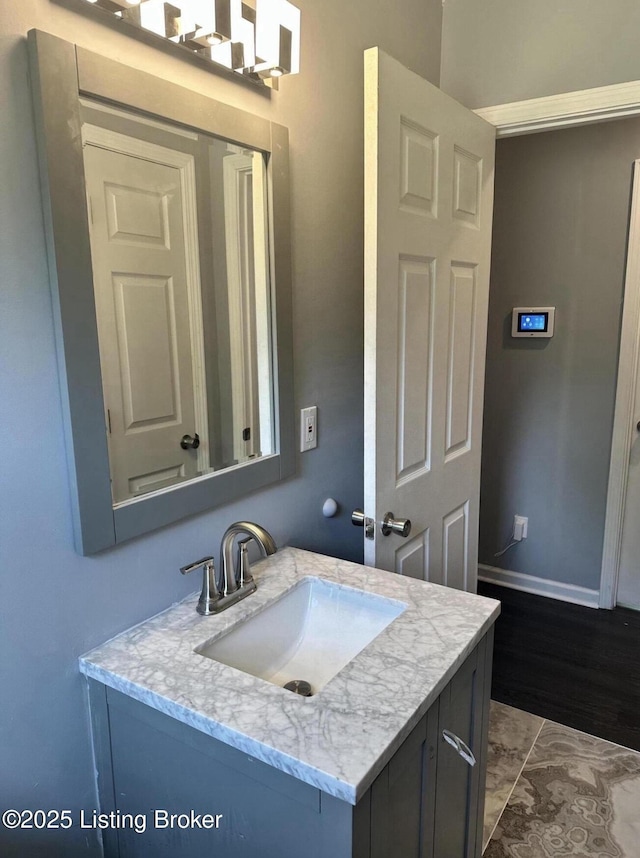 bathroom featuring marble finish floor, vanity, and baseboards