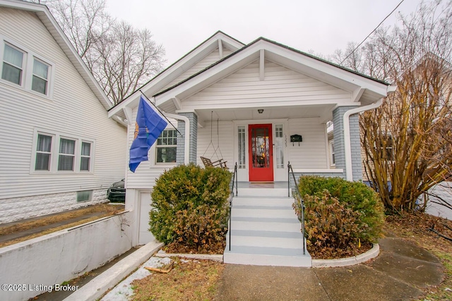 bungalow-style home with a garage and covered porch