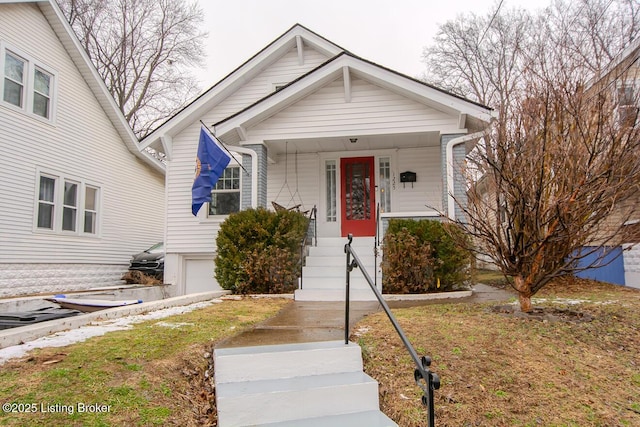 bungalow-style home with a garage and covered porch