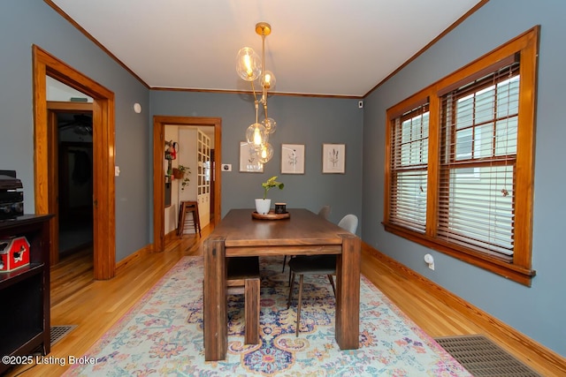 dining room featuring ornamental molding and light wood-type flooring