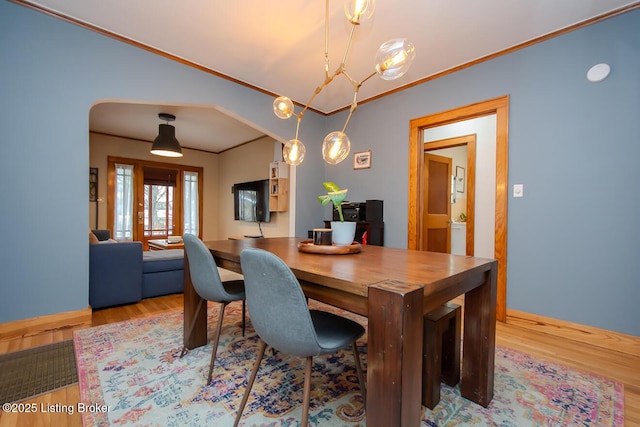 dining area featuring lofted ceiling, light hardwood / wood-style flooring, and ornamental molding