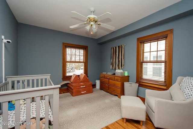 bedroom featuring multiple windows, light hardwood / wood-style flooring, and ceiling fan