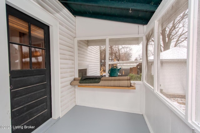 unfurnished sunroom with vaulted ceiling with beams