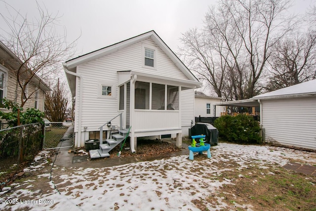 rear view of property featuring a sunroom