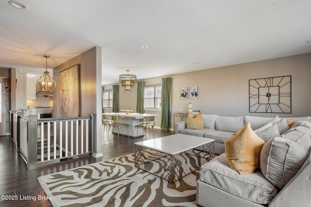 living room featuring an inviting chandelier and dark hardwood / wood-style floors