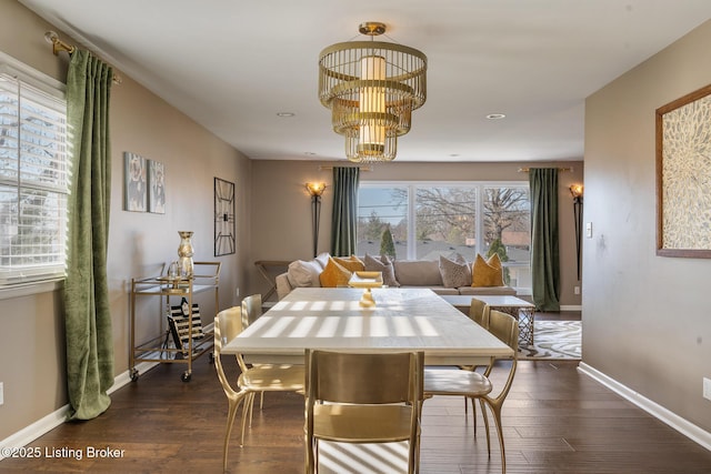 dining room with dark hardwood / wood-style flooring and a chandelier