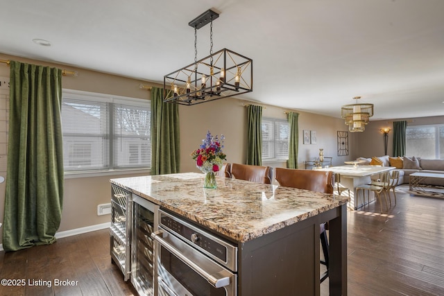 kitchen featuring a kitchen bar, dark hardwood / wood-style flooring, hanging light fixtures, and a kitchen island