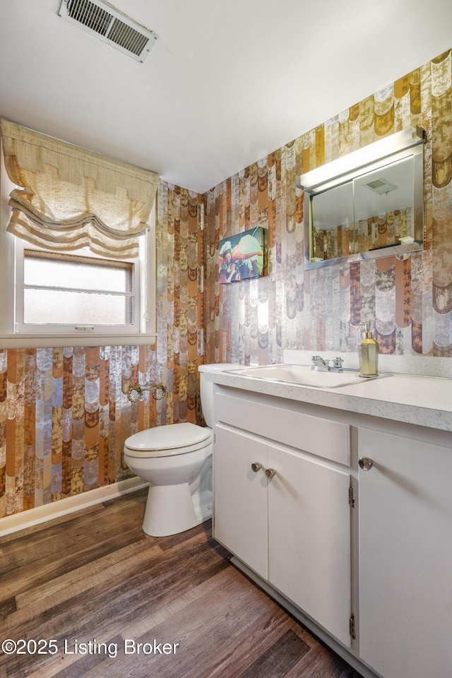 bathroom featuring vanity, hardwood / wood-style floors, and toilet