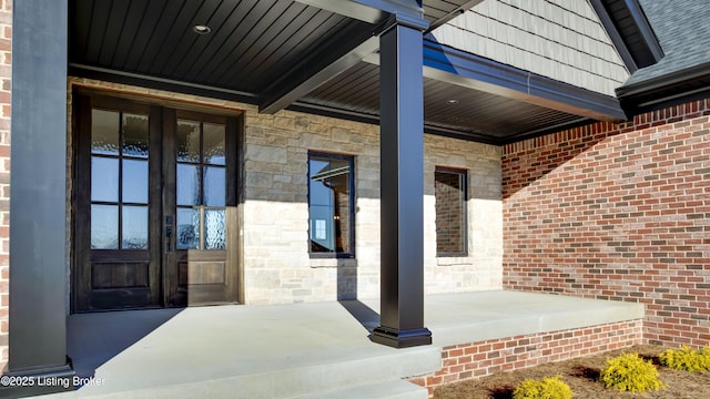 doorway to property featuring a porch and french doors