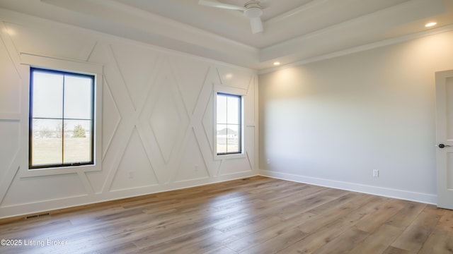 empty room with crown molding and light hardwood / wood-style flooring