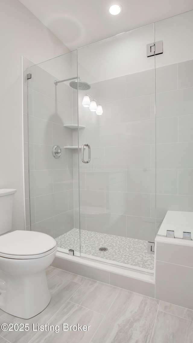 bathroom with toilet and a shower with shower door