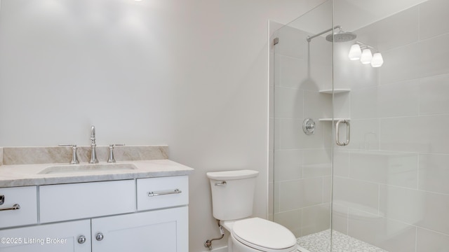 bathroom featuring vanity, toilet, and a shower with shower door