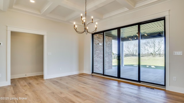 spare room featuring beamed ceiling, coffered ceiling, an inviting chandelier, and light hardwood / wood-style floors