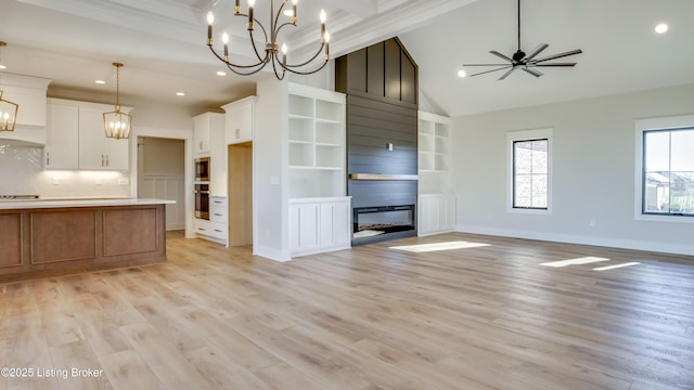 kitchen featuring white cabinetry, a large fireplace, a kitchen island, and pendant lighting