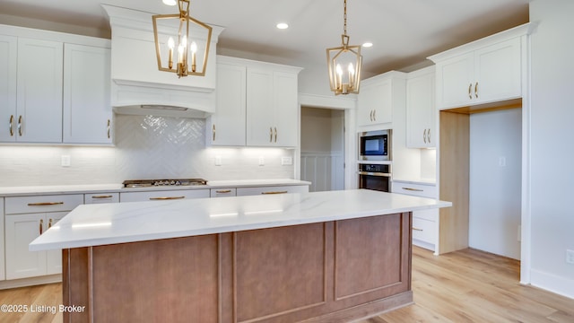 kitchen featuring pendant lighting, white cabinetry, stainless steel appliances, and a kitchen island