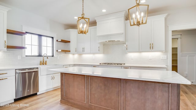 kitchen featuring pendant lighting, white cabinetry, a center island, light hardwood / wood-style floors, and stainless steel appliances