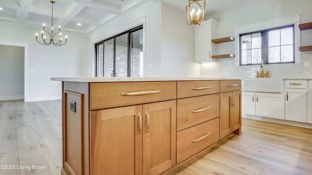 kitchen with white cabinetry, pendant lighting, light hardwood / wood-style floors, and a kitchen island