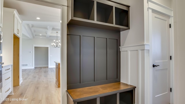 mudroom with beamed ceiling, coffered ceiling, an inviting chandelier, and light hardwood / wood-style floors