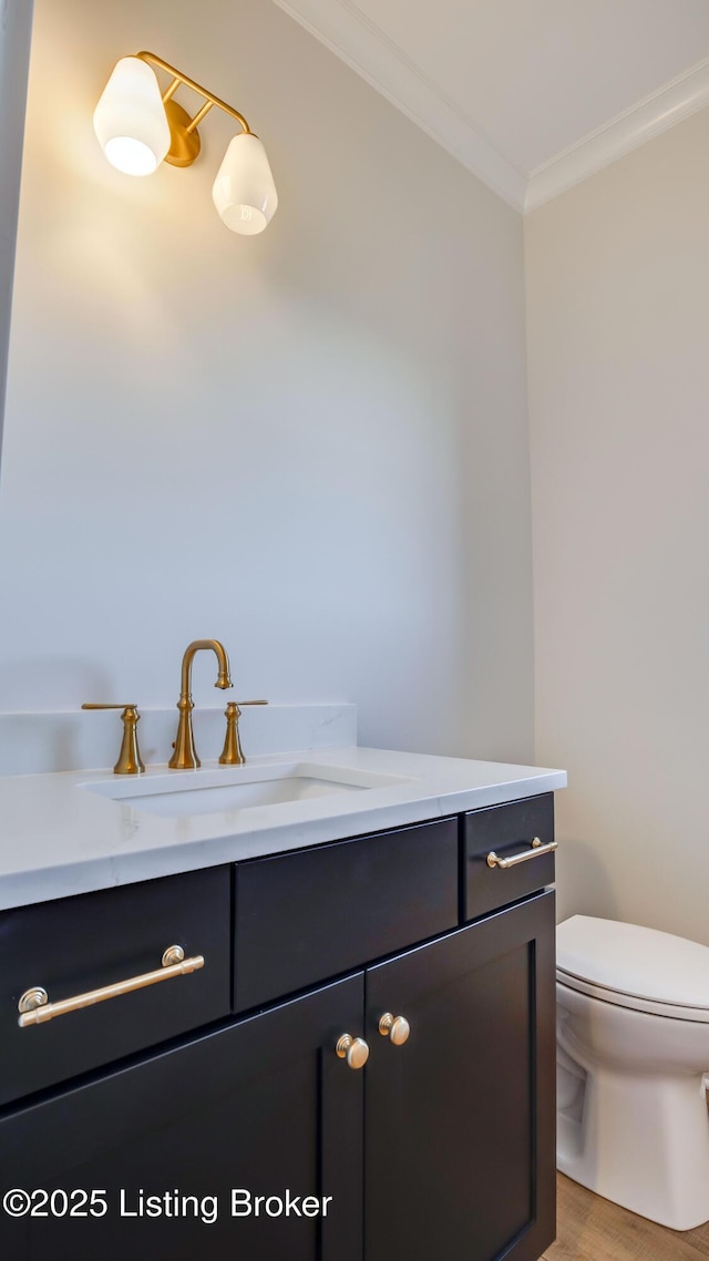 bathroom with crown molding, vanity, toilet, and wood-type flooring