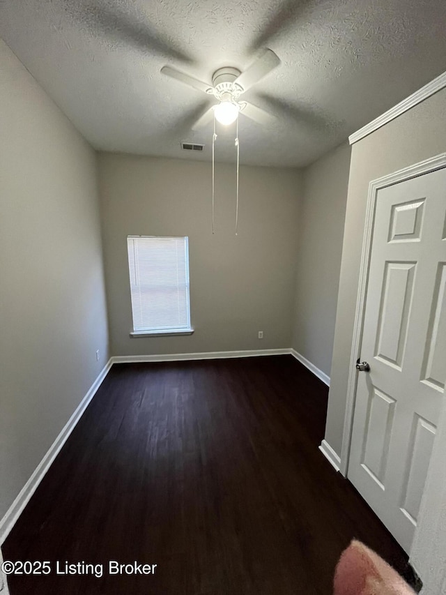 spare room featuring ceiling fan, a textured ceiling, and dark hardwood / wood-style flooring