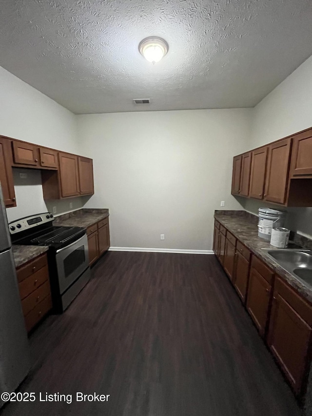 kitchen featuring sink, stainless steel appliances, dark hardwood / wood-style floors, and a textured ceiling