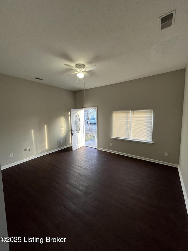 spare room featuring dark wood-type flooring and ceiling fan