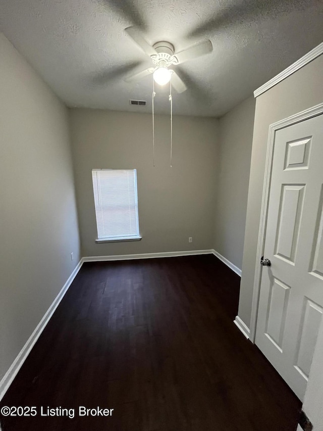 empty room with dark hardwood / wood-style flooring and a textured ceiling