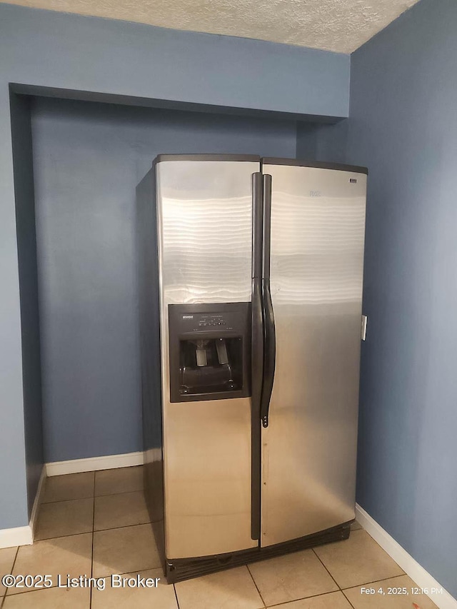 interior details with stainless steel refrigerator with ice dispenser and a textured ceiling