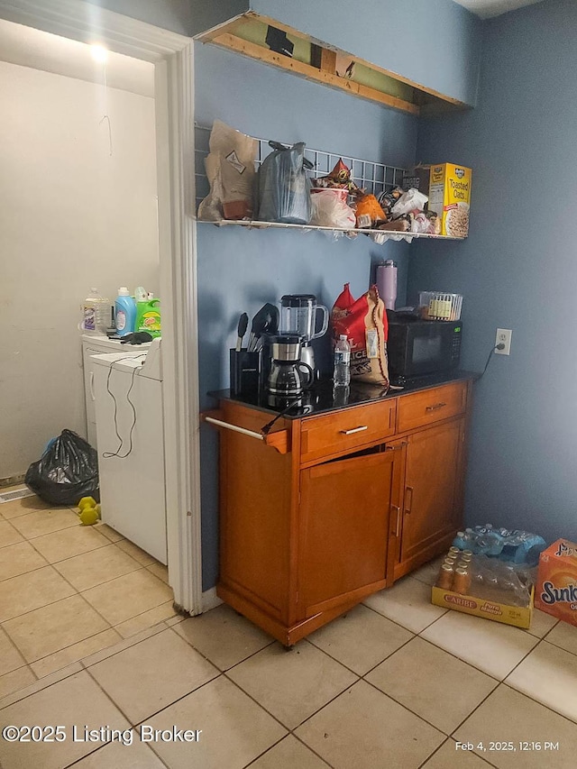 kitchen with washer / dryer and light tile patterned floors