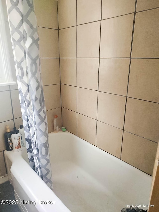 bathroom featuring tile walls and shower / bath combo