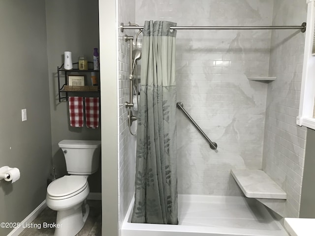 bathroom featuring toilet and a shower with shower curtain