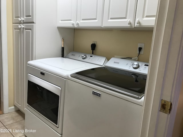 laundry room with cabinets, light tile patterned floors, and independent washer and dryer