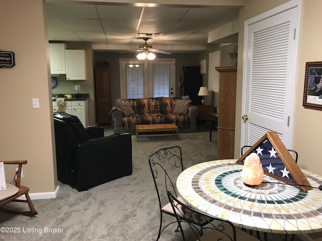 dining room featuring light carpet, a drop ceiling, and ceiling fan