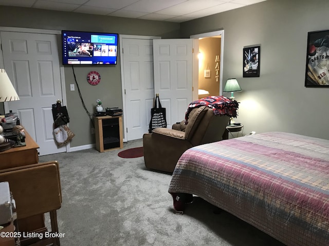 carpeted bedroom with a drop ceiling