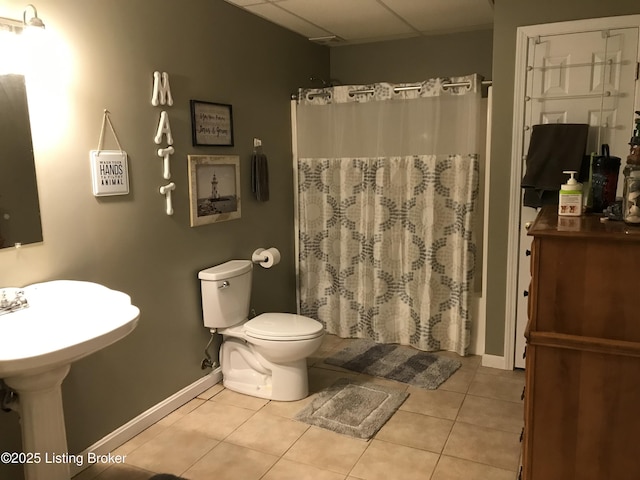 bathroom with a shower with curtain, tile patterned floors, and toilet