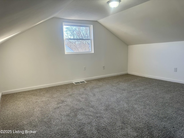 additional living space featuring lofted ceiling and carpet