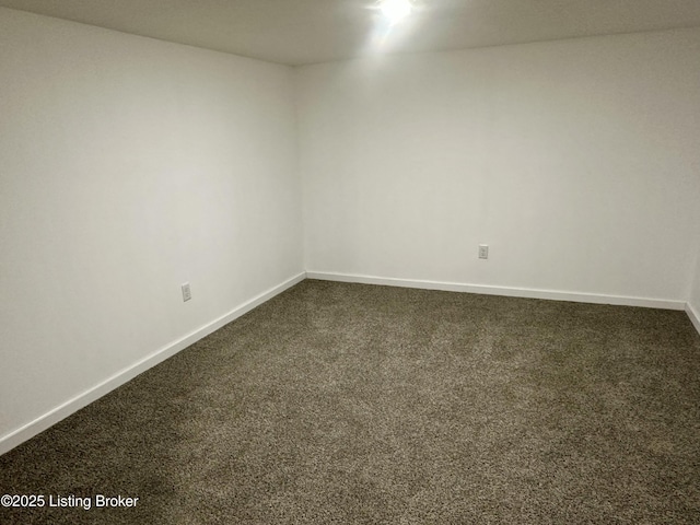 spare room featuring dark carpet